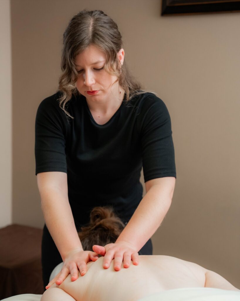 a massage therapist is giving a woman a deep tissue massage in a quiet private room
